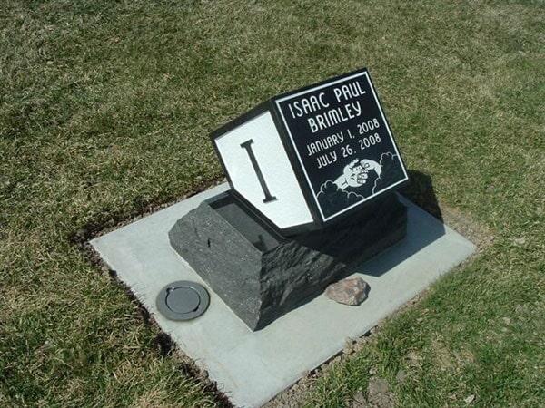 Small black and white infant marker set on a rough natural stone base