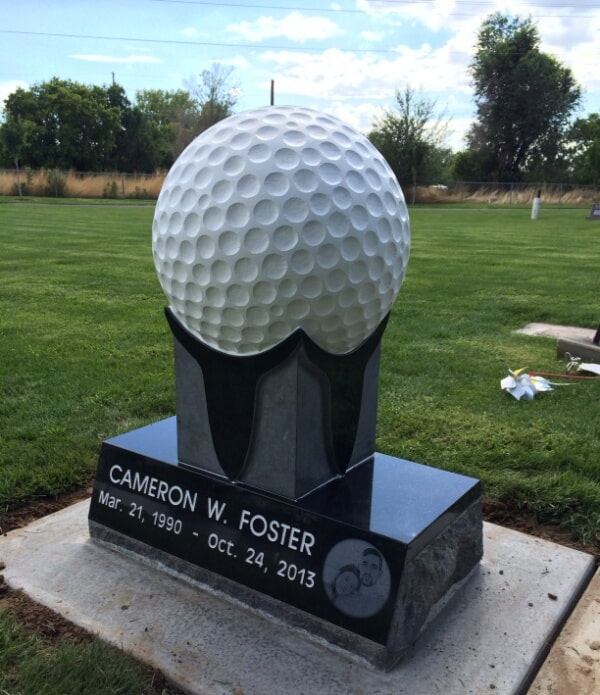 Granite golf ball carved full size on a tee above a black base
