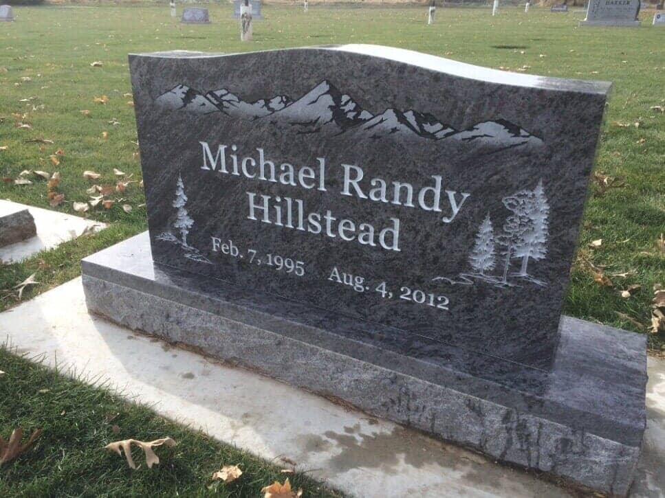 Grey granite upright etched with the Wasatch range and pine trees