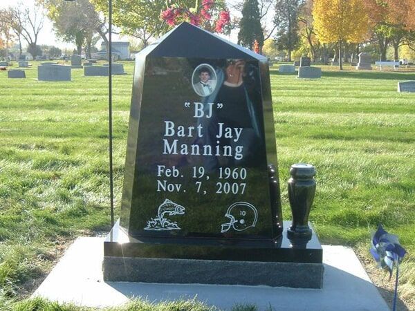 Tapered black granite upright with a cameo portrait and sport etchings