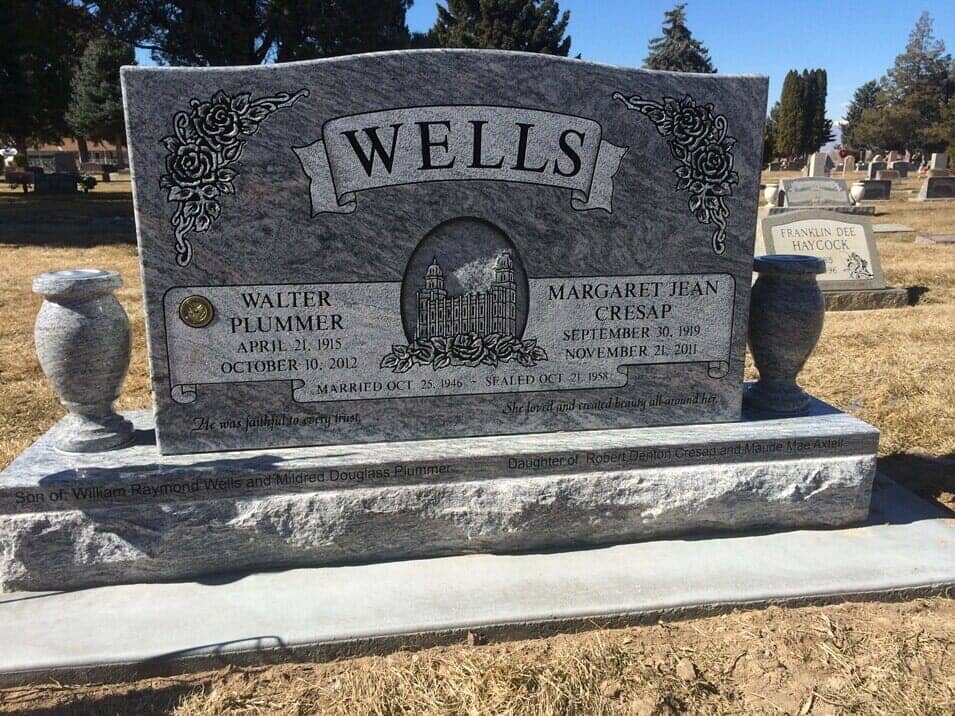 Large grey companion monument with fluted columns and matching granite vases