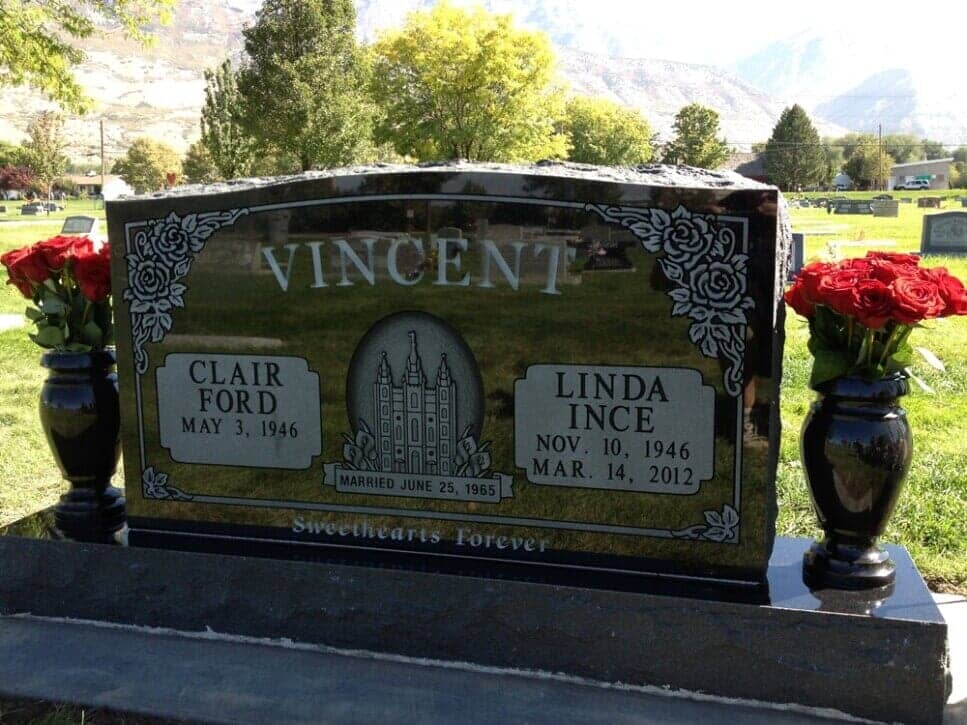 Black granite companion monument with a temple etching and carved roses